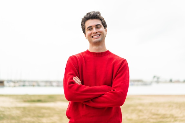 Young handsome man keeping the arms crossed in frontal position