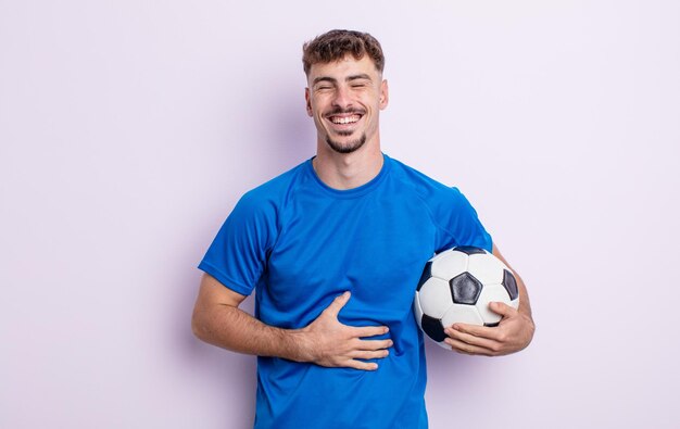 Young handsome man laughing out loud at some hilarious joke soccer concept