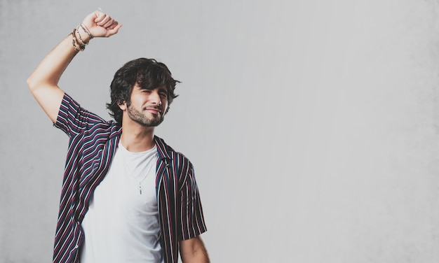 Young handsome man Listening to music, dancing and having fun, moving, shouting and expressing happiness, freedom concept