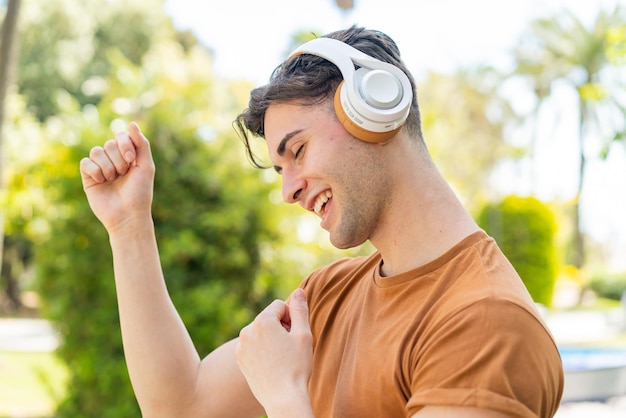 Young handsome man listening music and dancing