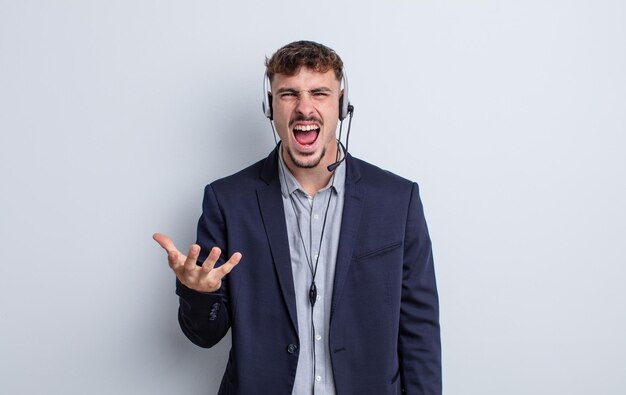 Young handsome man looking angry, annoyed and frustrated. telemarketer concept