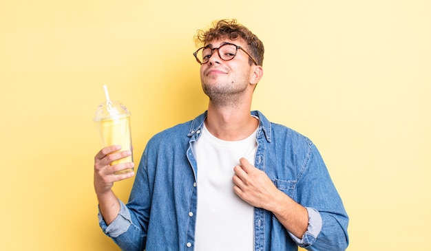 Young handsome man looking arrogant, successful, positive and proud. milkshake concept