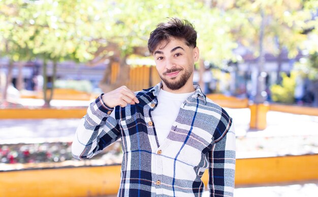 Foto giovane bell'uomo che sembra arrogante positivo e orgoglioso di successo che indica se stesso