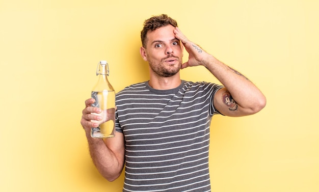 Young handsome man looking happy, astonished and surprised. water concept