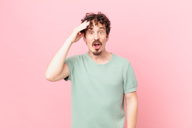 Young handsome man looking happy, astonished and surprised