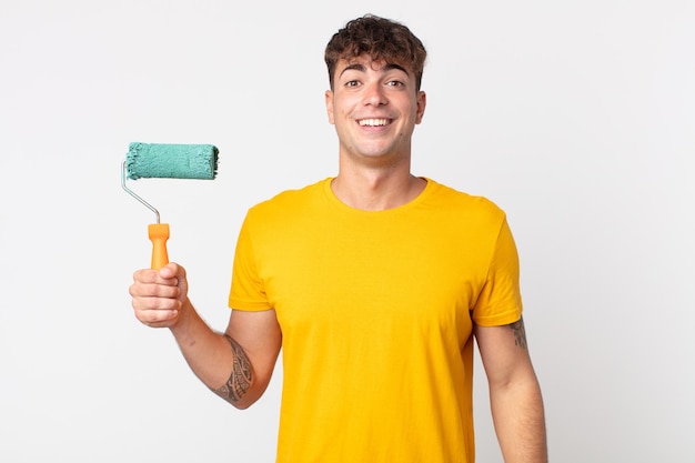 young handsome man looking happy and pleasantly surprised. painting home concept