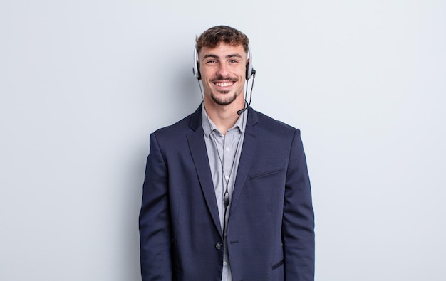 Young handsome man looking happy and pleasantly surprised telemarketer concept