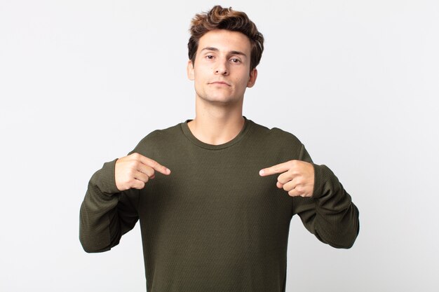 Young handsome man looking proud, positive and casual pointing to chest with both hands