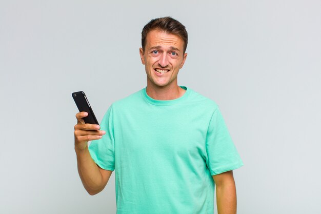 困惑し混乱している若いハンサムな男、問題への答えを知らない、緊張したジェスチャーで唇をかむ