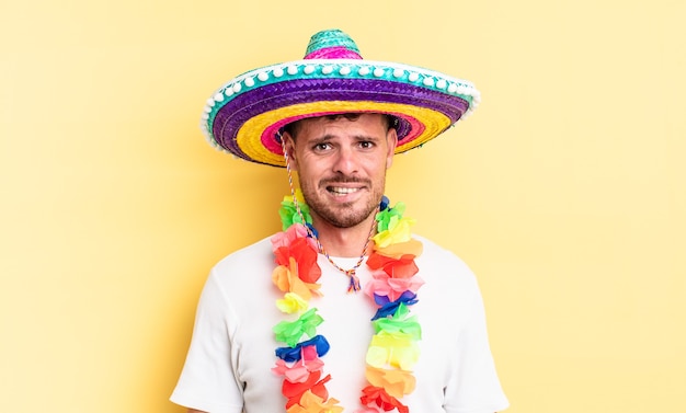 Young handsome man looking puzzled and confused. mexican party concept