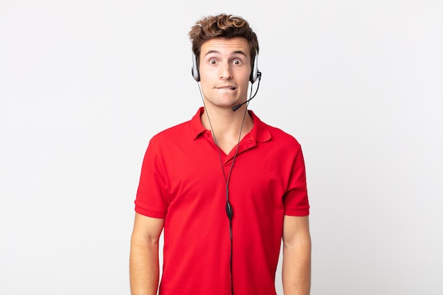 Young handsome man looking puzzled and confused. telemarketer concept