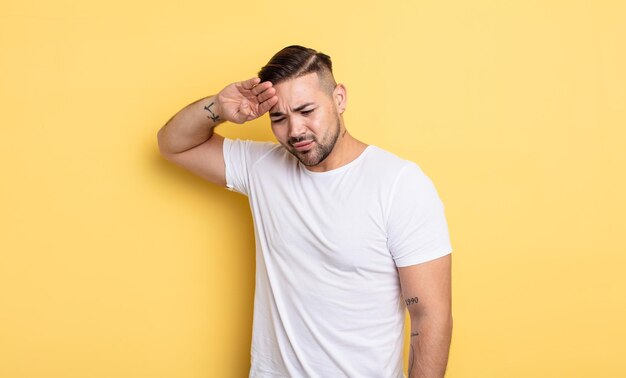 ストレス、疲れ、イライラ、額から汗を乾かし、絶望と疲れを感じている若いハンサムな男