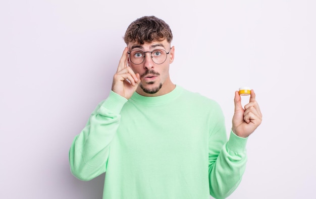 Photo young handsome man looking surprised, realizing a new thought, idea or concept. contact lenses