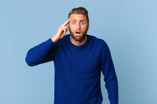 Young handsome man looking surprised, realizing a new thought, idea or concept