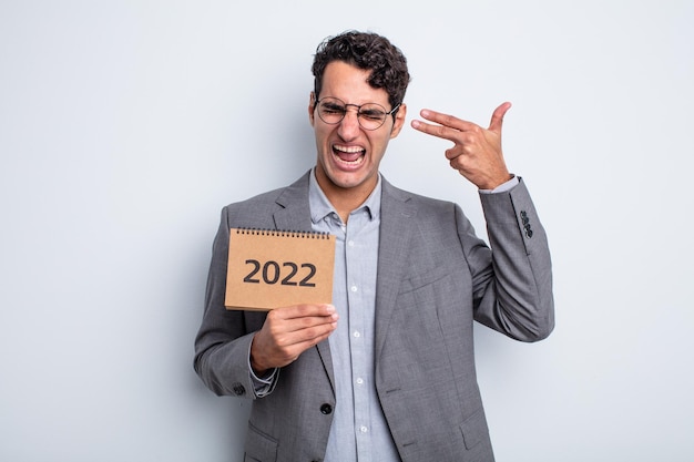 Young handsome man looking unhappy and stressed, suicide gesture making gun sign. calendar concept