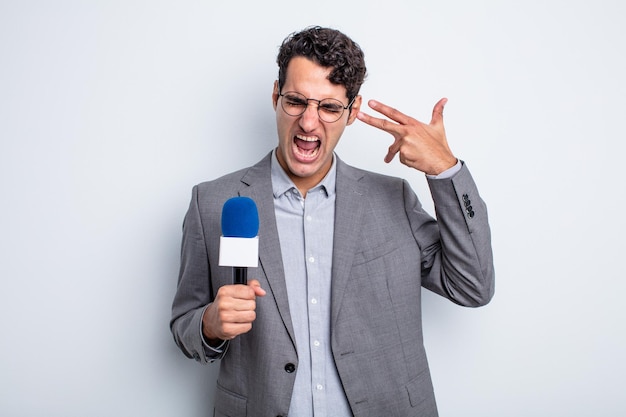 Young handsome man looking unhappy and stressed, suicide gesture making gun sign. presenter with microphone