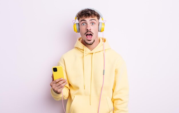 Young handsome man looking very shocked or surprised. music concept