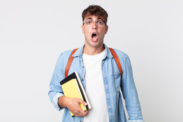 Young handsome man looking very shocked or surprised. university student concept