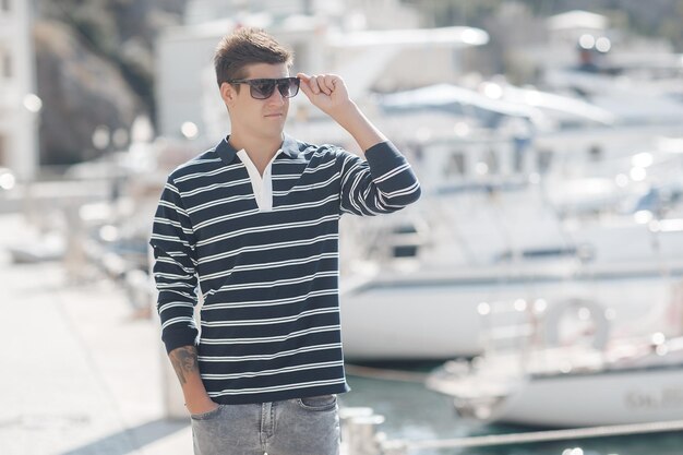 Photo young handsome man outdoor near yachts