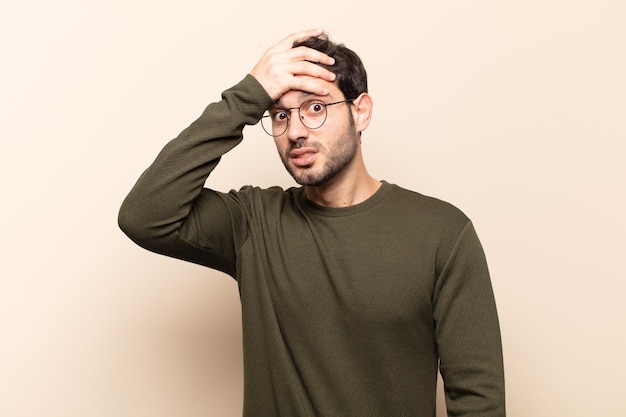 Young handsome man panicking over a forgotten deadline, feeling stressed, having to cover up a mess or mistake