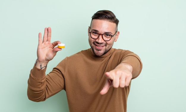 Young handsome man pointing at camera choosing you. contact lens