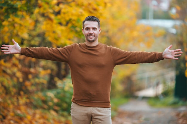 Young handsome man posing in autumn park