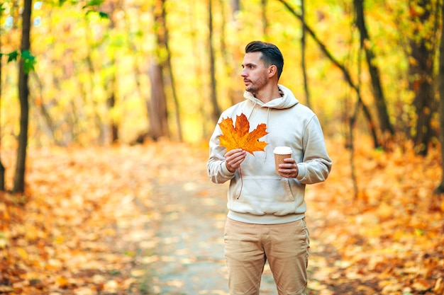 Photo young handsome man posing in autumn park