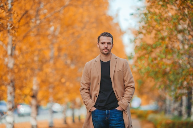 Young handsome man posing in autumn park