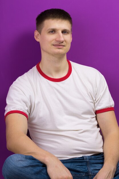 Young handsome man posing on purple background