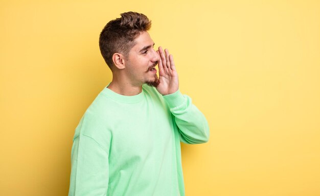 Young handsome man profile view, looking happy and excited, shouting and calling to copy space on the side. strange moustache concept