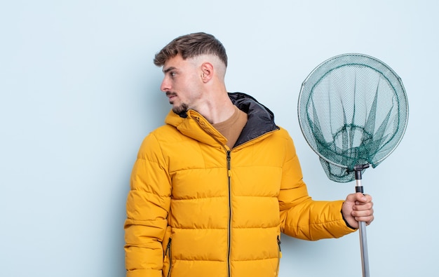 Young handsome man on profile view thinking, imagining or\
daydreaming. fisherman concept