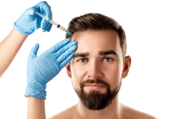 Young handsome man receiving facial injection for skin rejuvenation on white background