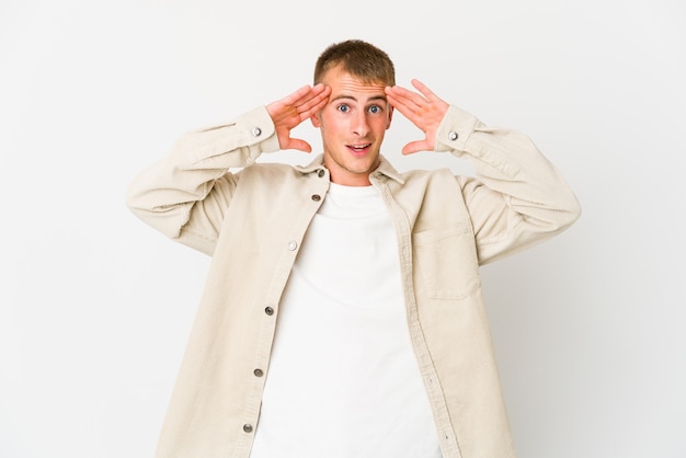 Young handsome man receiving a pleasant surprise, excited and raising hands