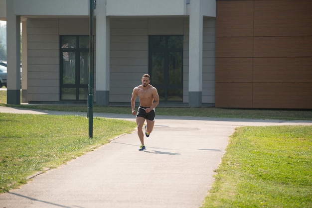 公園で走っている若いハンサムな男