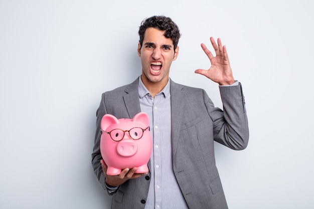 Young handsome man screaming with hands up in the air. piggy bank concept