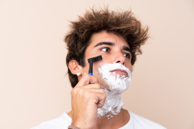 Young handsome man shaving his beard