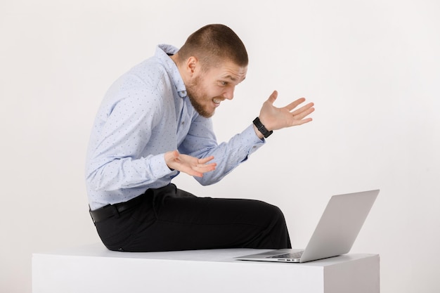 Giovane uomo bello in camicia e cravatta facendo uso del computer portatile