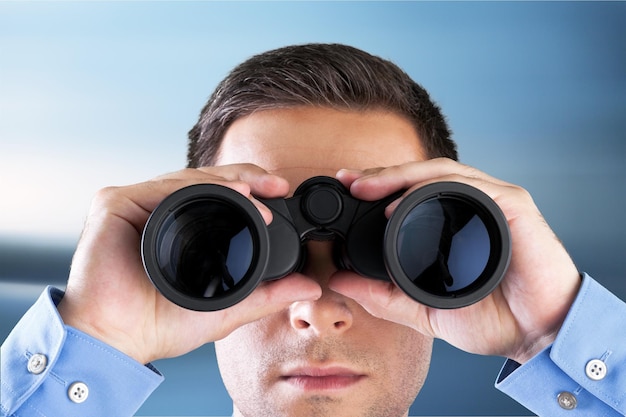 Young handsome man in shirt  with binoculars