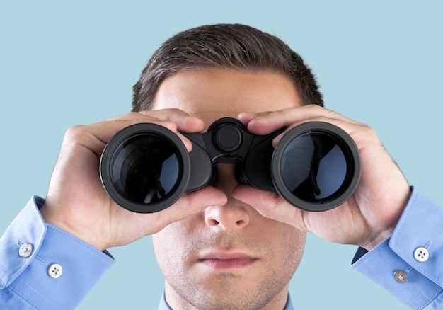 Young handsome man in shirt  with binoculars