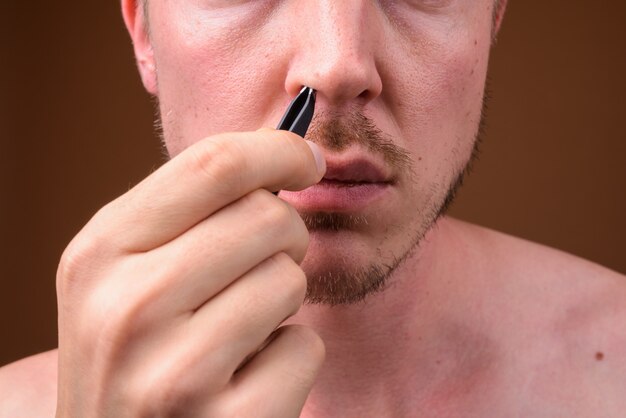 young handsome man shirtless while grooming 