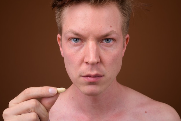 Young handsome man shirtless while grooming