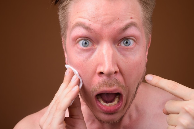 Young handsome man shirtless while grooming