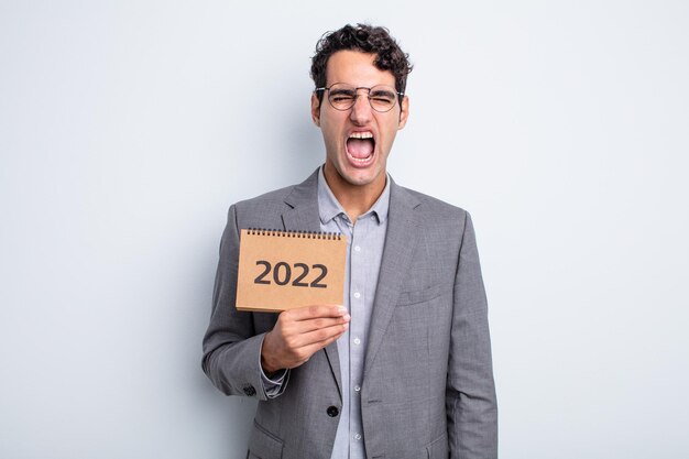 Young handsome man shouting aggressively looking very angry calendar concept