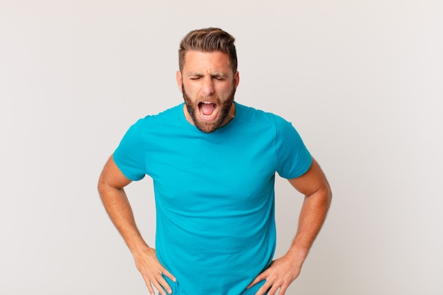 Young handsome man shouting aggressively, looking very angry