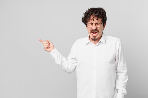 Young handsome man shouting aggressively, looking very angry