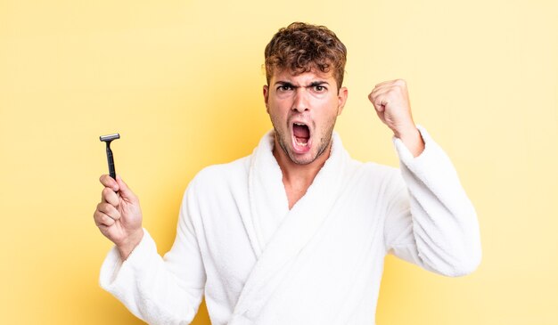 Young handsome man shouting aggressively with an angry expression. shaving concept