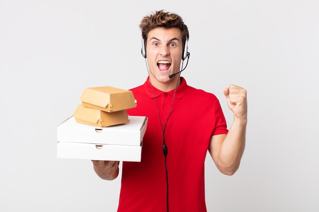 Young handsome man shouting aggressively with an angry expression. take away fast food concept