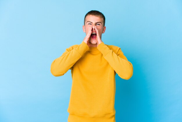 Young handsome man shouting excited to front