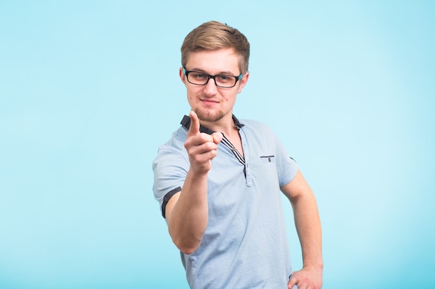 Young handsome man showing finger pointing towards