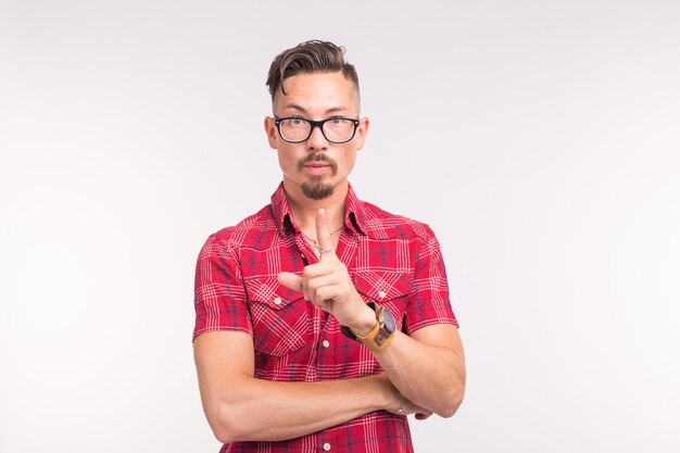 young handsome man showing finger up on white wall